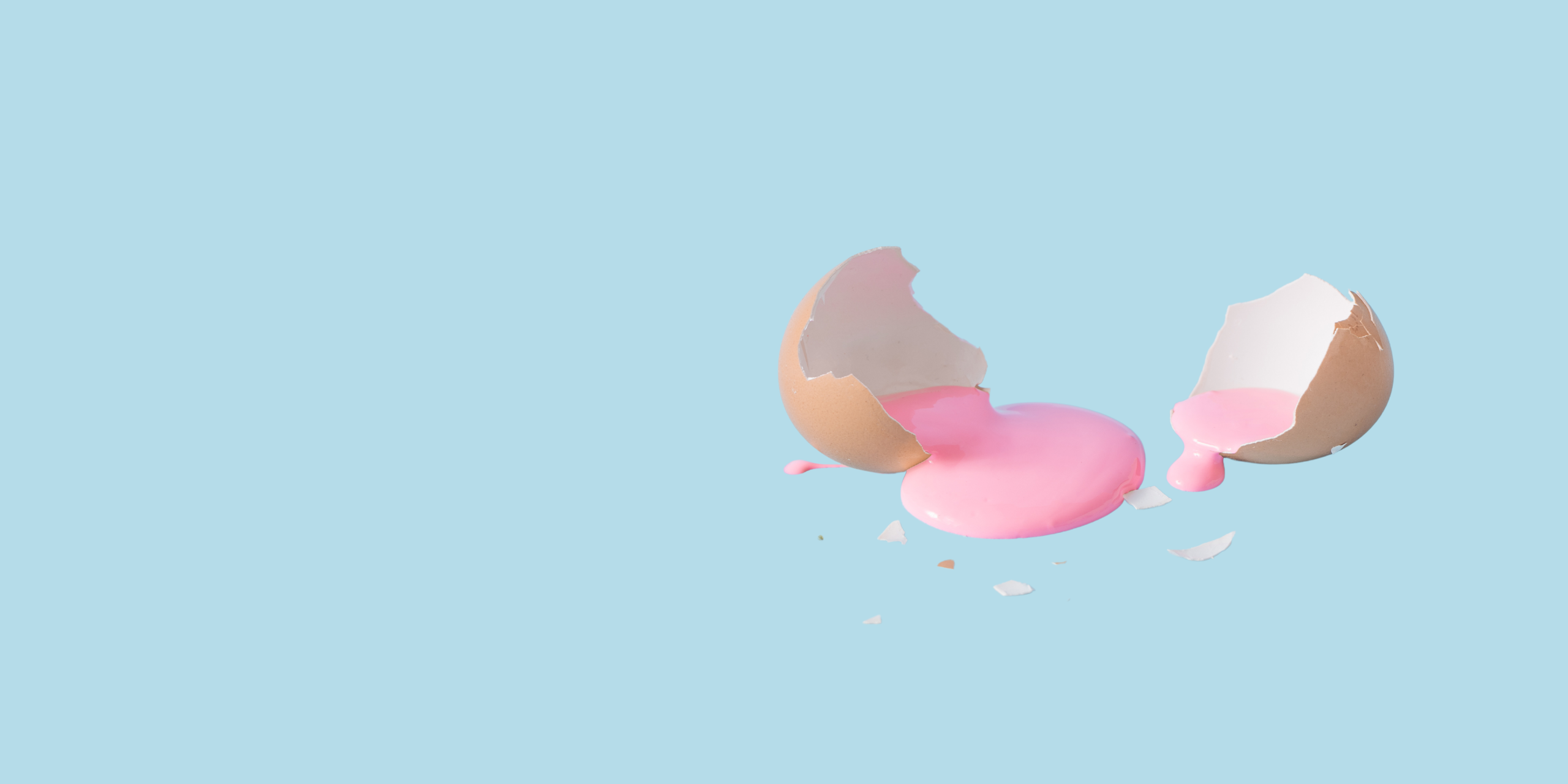 Creatieve visual van een gebroken ei, waar een roze ei inzit.